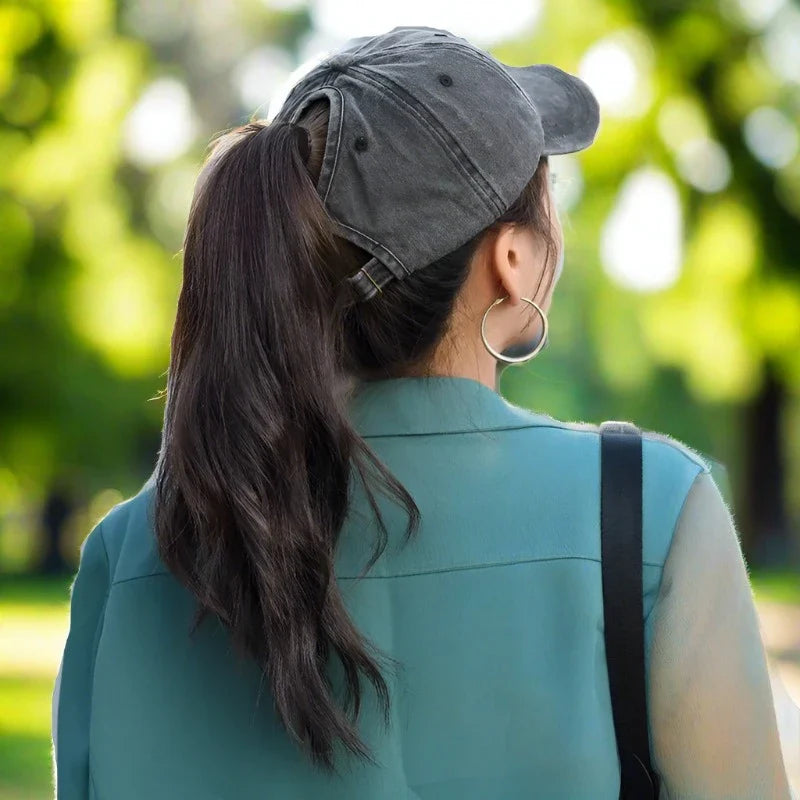 A young lady sports a stylish ponytail cap.