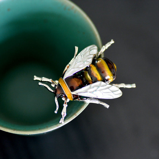 shiny bee broach on mug rim